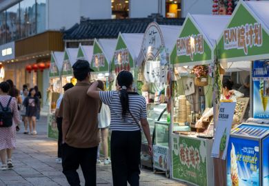 A couple walks past ice cream stalls during an evening festival in Suzhou, China.