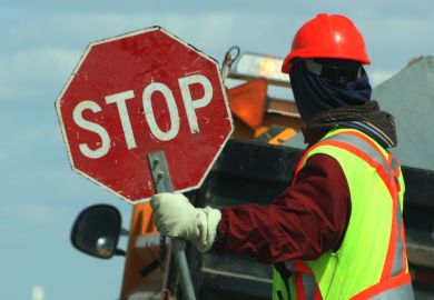  Worker Holding Stop Sign Against Vehicle On Road