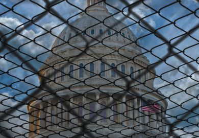 The US Capitol building in Washington behind barbed wire 