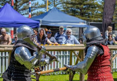Knights in metal helmets and armor fight, a part of a costume performance at a public festival, reconstruction of knightly battles. Knights in metal helmets and armor fight, a part of a costume performance at a public festival, reconstruction of knightly battles.