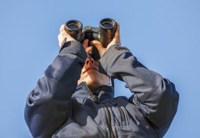 Young woman looking in binoculars