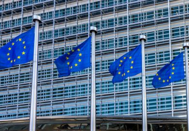 Four European flags fluttering against the headquarters of the European Commission