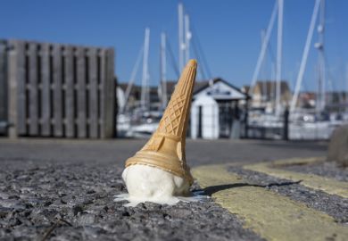 A dropped ice cream cone melting on a sunny road