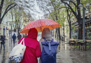 two women under one umbrella.