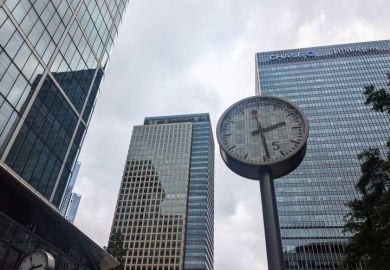 A public clock stands at Reuters Plaza before the modern glass skyscrapers, including the JP Morgan Chase building, in the Canary Wharf financial district 