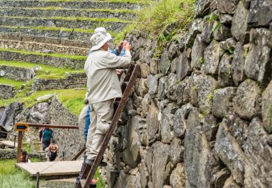 Conservation workers performing maintenance on the stone terrace walls at the Historic Sanctuary of Machu Picchu