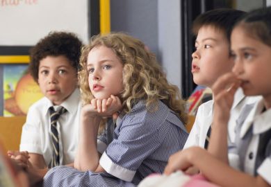 Thoughtful elementary students sitting in classroom