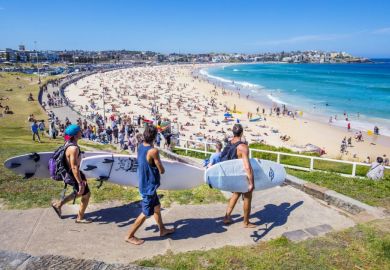 Three surfers heading to the Bondi Beach Bondi beach with their surf boards on a sunny day. Three surfers heading to the Bondi Beach Bondi beach with their surf boards on a sunny day.