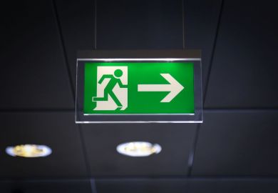 Emergency exit sign above a black doorway