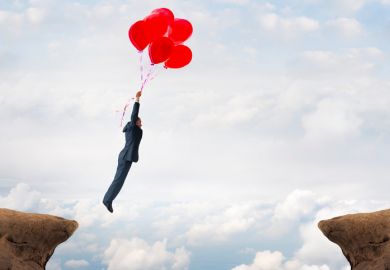 Man floating over crevasse on balloons