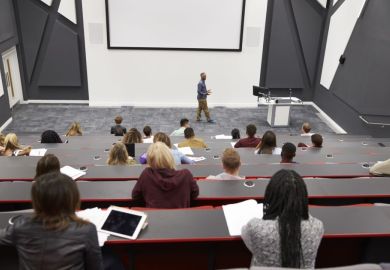 Man lectures students in lecture theatre