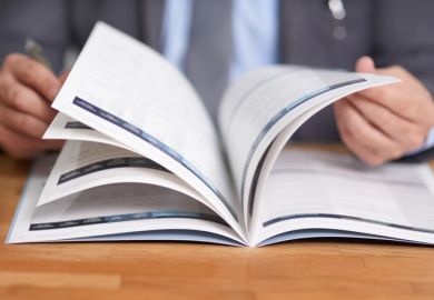A close-up of a person flicking though a book