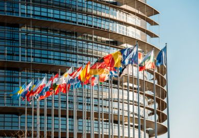 The European Parliament building in Strasbourg, France with flags waving on a spring evening