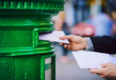  man posting mail into a postbox in the city