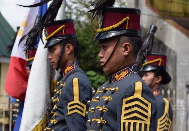Male College military cadet on standing formation holding national flag. Male College military cadet on standing formation holding national flag.
