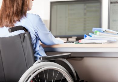 A wheelchair users works at a computer