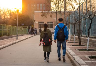 Two Chinese students Walking Side by Side on University Campus in Xi'an, China March 2018