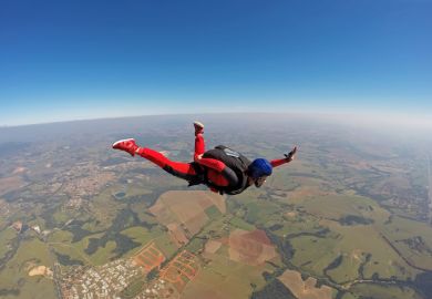 Falling skydiver opening parachute