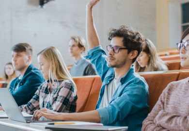 Student uses laptop while listening to a lecture at a university