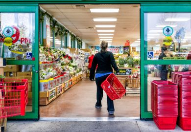 Trader Joe's customer with shopping basket by store entrance