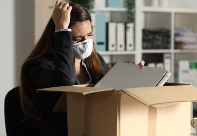 A woman packs her things after being fired
