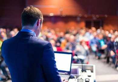 Speaker giving presentation at conference Speaker giving presentation at conference