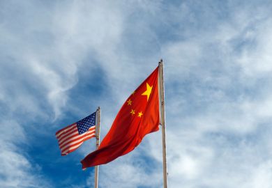 US and China flags against blue sky