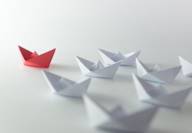 Red paper boat in the lead Paper boat leading series of boats