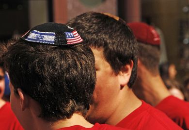 Young man wearing yarmulke with American and Israeli flags Young man wearing yarmulke with American and Israeli flags