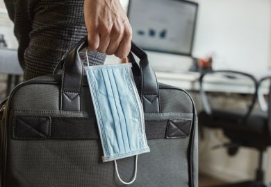 A person carrying a surgical mask and a briefcase A person carrying a surgical mask and a briefcase, symbolising working during the Covid-19 pandemic