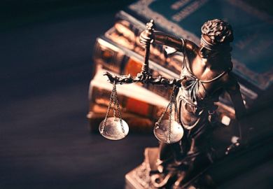A justice statue next to some books