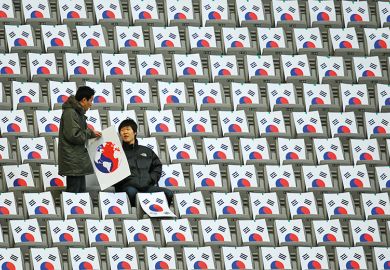 South Koreans sit in seats with the South Korean national flag at the Seoul World Cup Stadium in Seoul