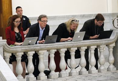 people work on laptops on balcony