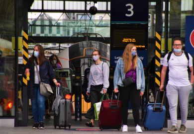 London, United Kingdom - August 17 2020 Passengers with protective face masks and luggage leaving King's Cross Station
