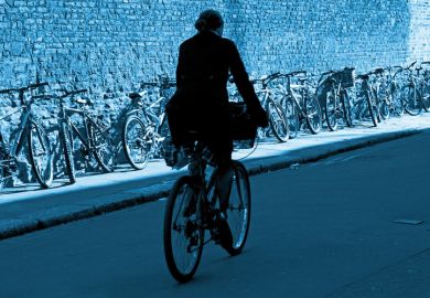 Male cyclist riding bike, Trinity Lane, Cambridge