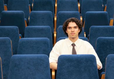 Male student sitting alone in lecture hall
