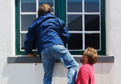 Man being lifted up to look through window Man being lifted up to look through window
