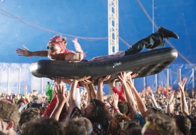 Man crowd surfing on inflatable bed, Bestival 2015, Isle of Wight Man crowd surfing on inflatable bed, Bestival 2015, Isle of Wight