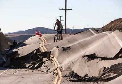 Man cycles along severely damaged road Man cycles along severely damaged road