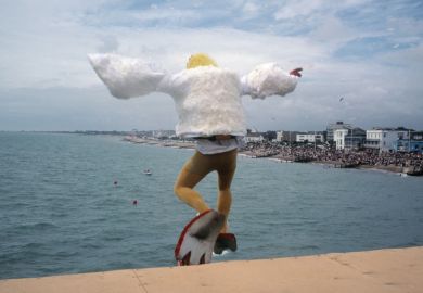 Man dressed as bird jumping into sea, Bognor Regis, England