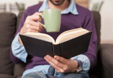 Man drinking coffee and reading book