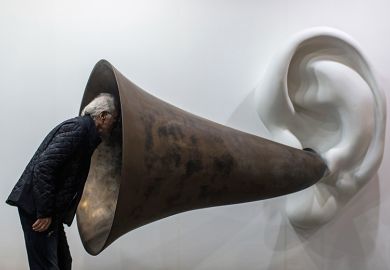 Man looking in to ear horn sculpture