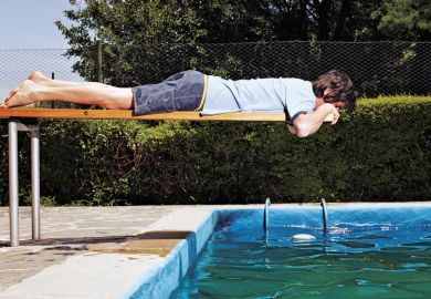 Man on diving board over swimming pool Man on diving board over swimming pool