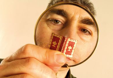 Man reading tiny book