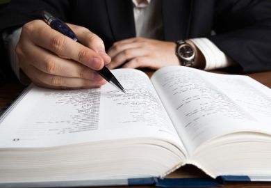 Man scanning dictionary page with pen