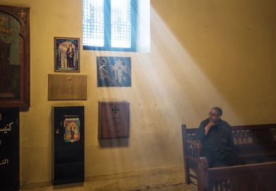 Man sitting in sunlight lit church