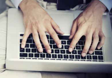 Man typing on Apple MacBook laptop keyboard