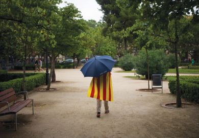 Man walks in rain wearing Catalan flag Man walks in rain wearing Catalan flag