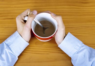 Man clutching coffee cup