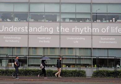 People walk past a science building at the University of Manchester, England